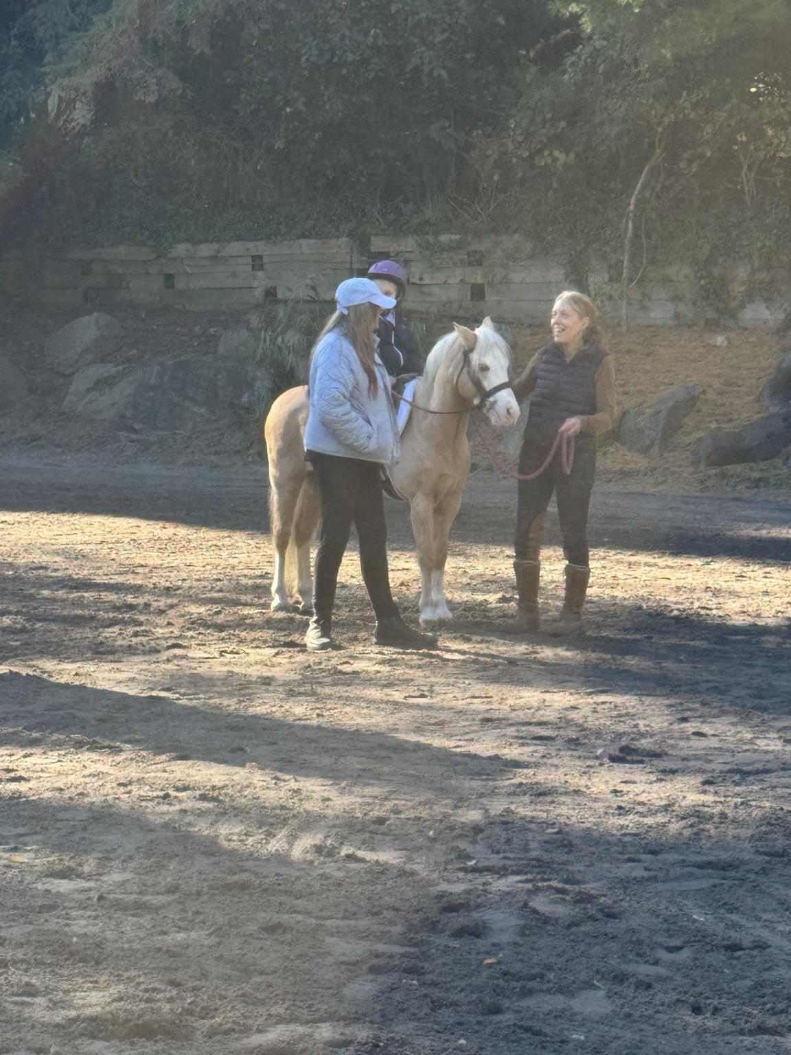 Young rider on a palomino pony with two helpers in the show ring